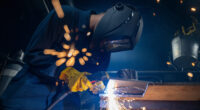 A technician cuts the baseplate of a 3D-printed vessel component